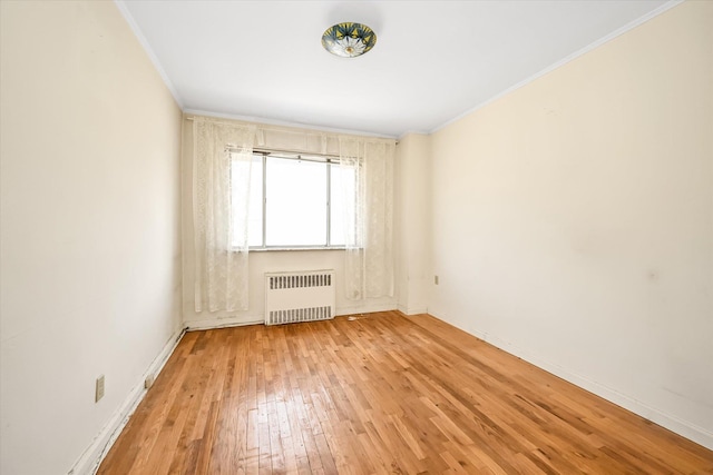 148-35 58th Ave, Flushing, NY 11355 - spare room featuring radiator heating unit, crown molding, light wood-style flooring, and baseboards