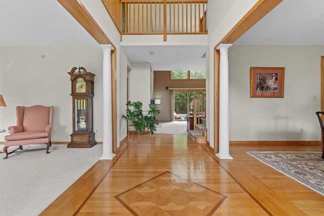 115 Moffat Rd, Washingtonville, NY 10992 - foyer entrance featuring ornate columns, a towering ceiling, baseboards, and light wood finished floors
