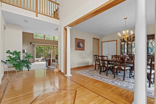 115 Moffat Rd, Washingtonville, NY 10992 - dining space featuring ornate columns, a chandelier, baseboards, a high ceiling, and wood finished floors
