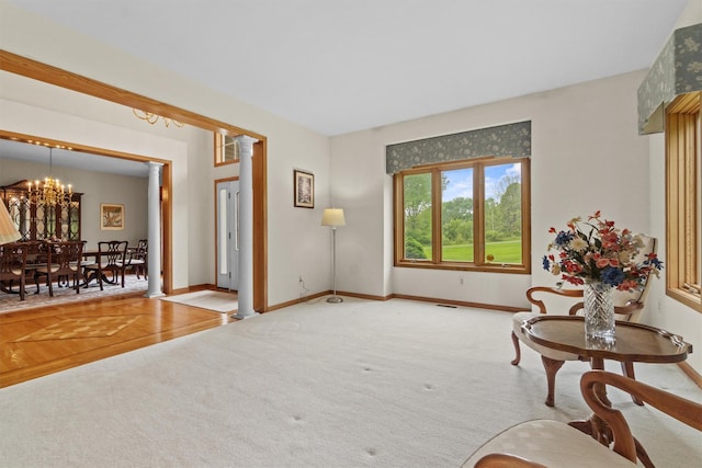 115 Moffat Rd, Washingtonville, NY 10992 - living area featuring a chandelier, carpet, baseboards, and ornate columns