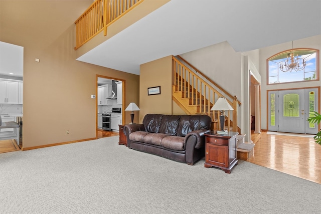 115 Moffat Rd, Washingtonville, NY 10992 - carpeted living room with a towering ceiling, stairway, a chandelier, and baseboards