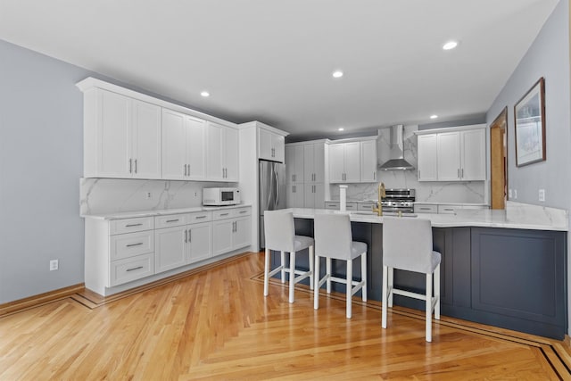 115 Moffat Rd, Washingtonville, NY 10992 - kitchen with wall chimney exhaust hood, stainless steel appliances, a kitchen bar, a peninsula, and backsplash