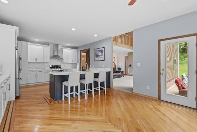 115 Moffat Rd, Washingtonville, NY 10992 - kitchen with wall chimney exhaust hood, appliances with stainless steel finishes, a breakfast bar area, a peninsula, and a sink