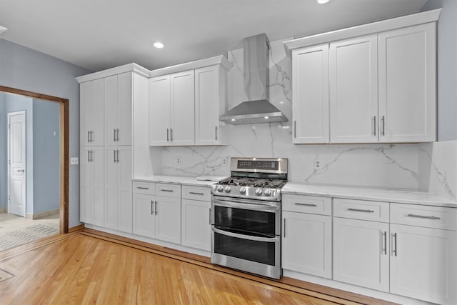 115 Moffat Rd, Washingtonville, NY 10992 - kitchen featuring double oven range, wall chimney range hood, white cabinets, recessed lighting, and backsplash