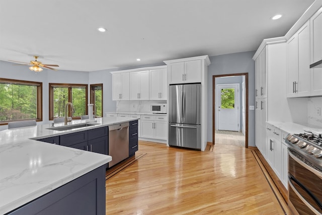 115 Moffat Rd, Washingtonville, NY 10992 - kitchen with stainless steel appliances, a sink, white cabinets, a ceiling fan, and recessed lighting