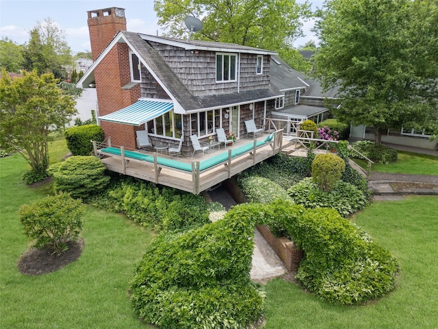 9 Lakeland Ave, Patchogue, NY 11772 - rear view of house with a chimney, a lawn, a deck, a shingled roof, and a standing seam roof