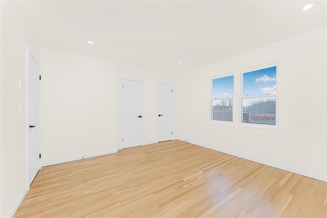 unfurnished room with light wood-style flooring, recessed lighting, and baseboards