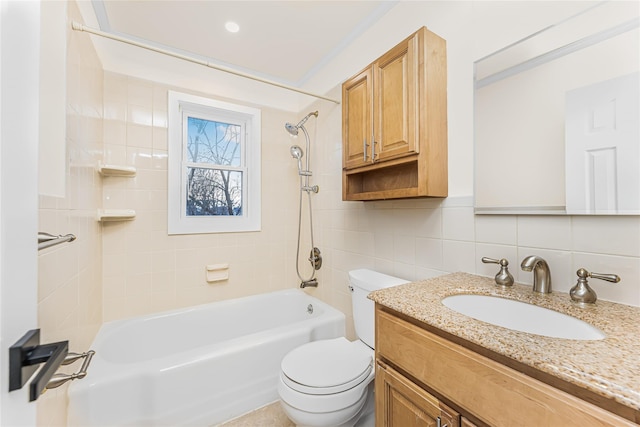 bathroom featuring toilet, backsplash, vanity,  shower combination, and tile walls