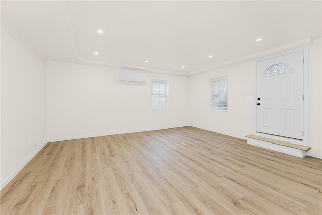 foyer entrance featuring a wall mounted AC, light wood-style floors, recessed lighting, and baseboards