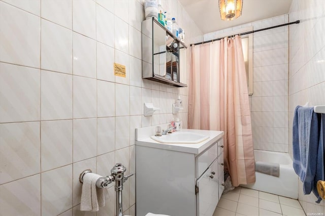 full bath with tile walls, shower / bathtub combination with curtain, tile patterned floors, and vanity