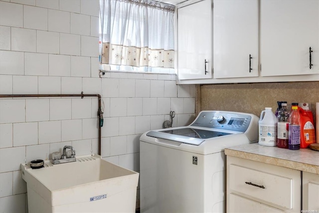 washroom with washer / dryer, cabinet space, and tile walls