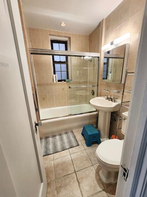 35-27 81st St Unit 2, Jackson Heights, NY 11372 - full bath with toilet, tile patterned floors, and combined bath / shower with glass door