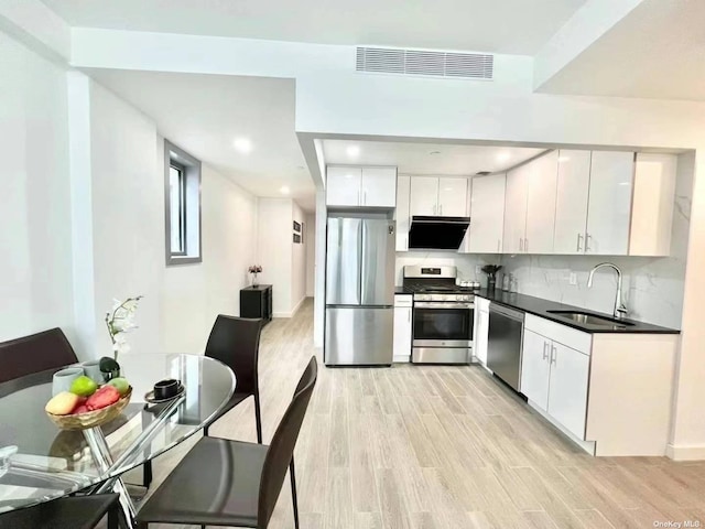 144-27 Sanford Ave Unit 2K, Flushing, NY 11355 - kitchen with appliances with stainless steel finishes, a sink, dark countertops, light wood finished floors, and recessed lighting