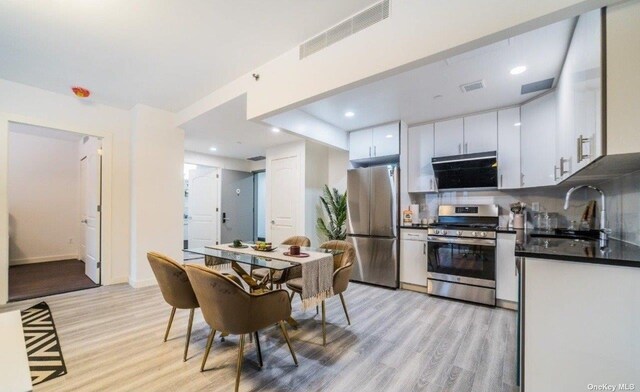 144-27 Sanford Ave Unit 2K, Flushing, NY 11355 - kitchen with appliances with stainless steel finishes, a sink, light wood-style floors, dark countertops, and white cabinets