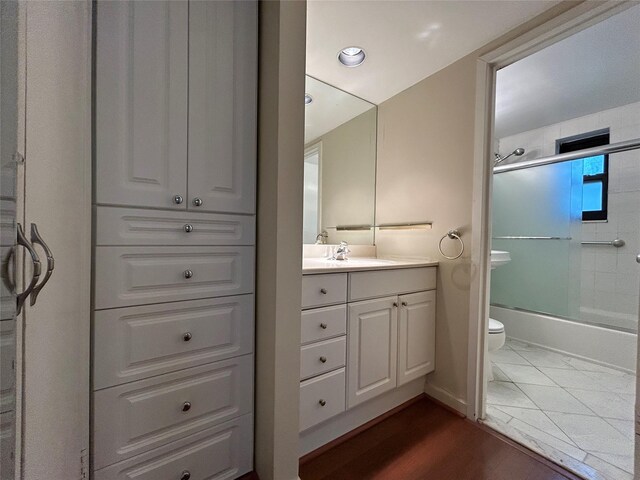 8 W Mill Dr Unit 1B, Great Neck, NY 11021 - full bathroom featuring toilet, vanity, shower / bath combination with glass door, recessed lighting, and wood finished floors