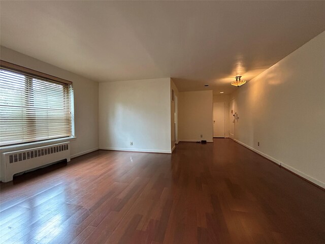 8 W Mill Dr Unit 1B, Great Neck, NY 11021 - unfurnished room with radiator, wood finished floors, and baseboards