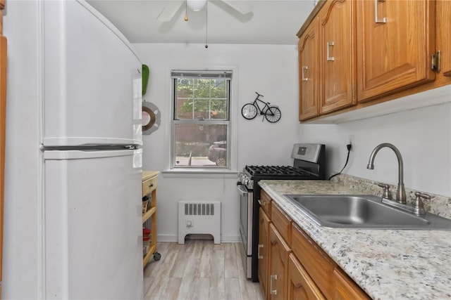 165 Columbus Ave Unit 1B, West Harrison, NY 10604 - kitchen featuring gas stove, freestanding refrigerator, a sink, a ceiling fan, and brown cabinetry