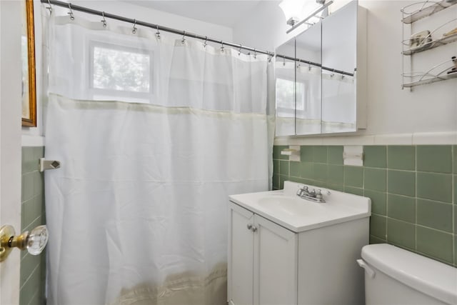 165 Columbus Ave Unit 1B, West Harrison, NY 10604 - full bathroom with tile walls, vanity, toilet, a shower with curtain, and a wainscoted wall