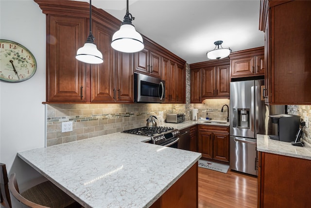 17-85 215th St Unit 4B, Bayside, NY 11360 - kitchen with stainless steel appliances, a sink, a peninsula, decorative backsplash, and light wood-type flooring