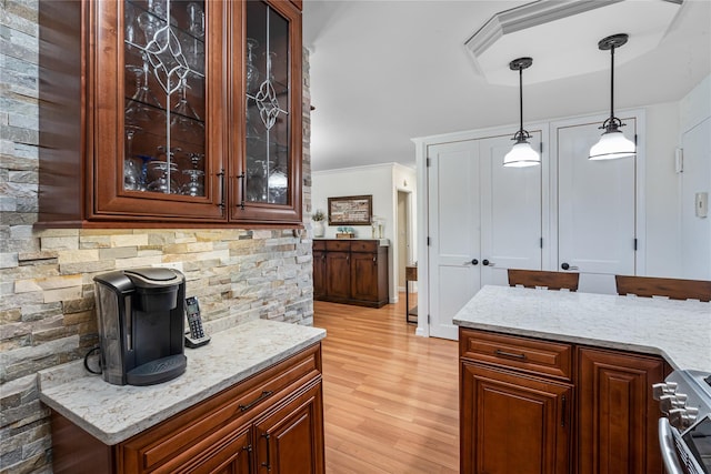 17-85 215th St Unit 4B, Bayside, NY 11360 - kitchen featuring stainless steel range with gas cooktop, decorative light fixtures, light stone counters, light wood-type flooring, and crown molding