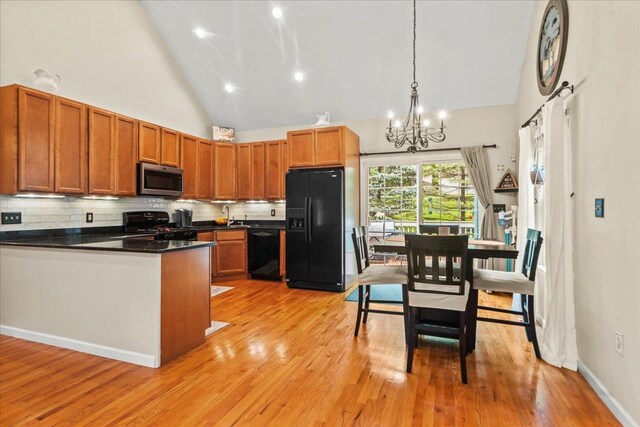 3 Pine Ln, Greenwood Lake, NY 10925 - kitchen featuring black appliances, high vaulted ceiling, a chandelier, tasteful backsplash, and dark countertops