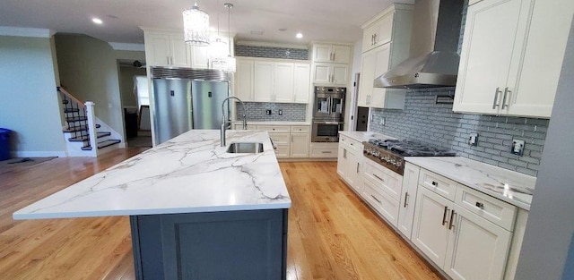 4 Coventry Ct, Wheatley Heights, NY 11798 - kitchen featuring wall chimney range hood, appliances with stainless steel finishes, a sink, crown molding, and a kitchen island with sink