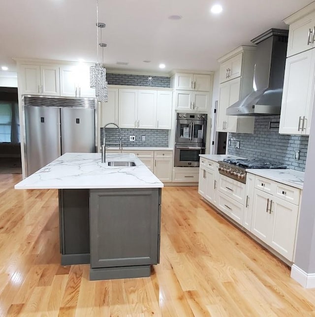 4 Coventry Ct, Wheatley Heights, NY 11798 - kitchen featuring a sink, wall chimney exhaust hood, stainless steel appliances, tasteful backsplash, and light stone counters