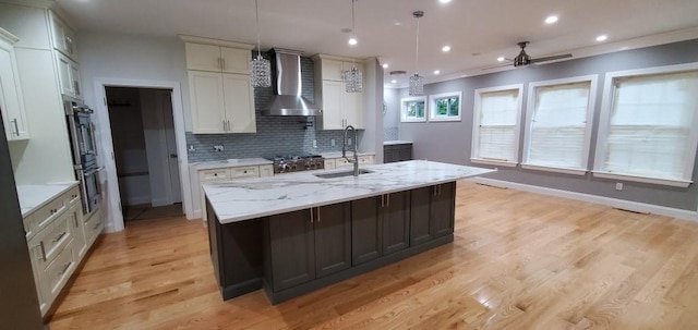 4 Coventry Ct, Wheatley Heights, NY 11798 - kitchen featuring wall chimney exhaust hood, a ceiling fan, tasteful backsplash, light wood-style flooring, and a sink