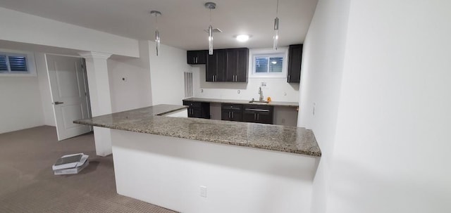 4 Coventry Ct, Wheatley Heights, NY 11798 - kitchen with carpet floors, a sink, light stone counters, decorative light fixtures, and a peninsula