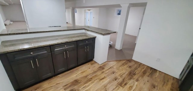 4 Coventry Ct, Wheatley Heights, NY 11798 - kitchen with light stone counters, light wood-style flooring, decorative columns, and a peninsula