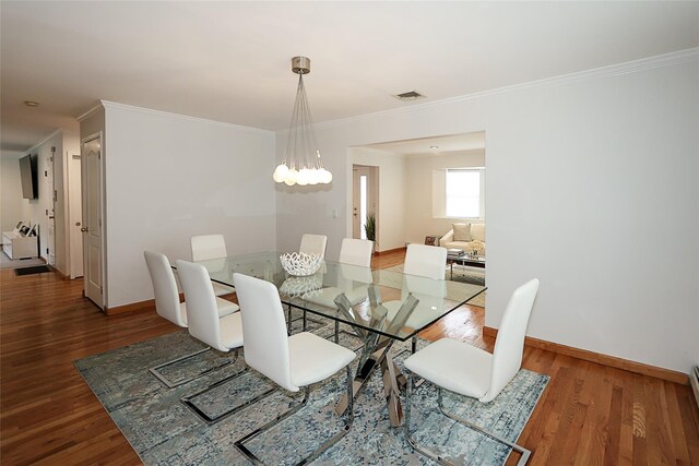 2448 6th Ave, East Meadow, NY 11554 - dining area featuring ornamental molding, baseboards, wood finished floors, a chandelier, and a baseboard heating unit