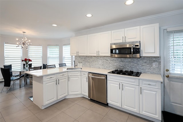 2448 6th Ave, East Meadow, NY 11554 - kitchen featuring stainless steel appliances, a chandelier, a peninsula, light countertops, and ornamental molding