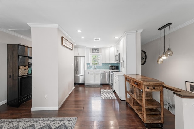 116 Westend Ave Unit 12, Freeport, NY 11520 - kitchen with appliances with stainless steel finishes, dark wood-style flooring, backsplash, ornamental molding, and white cabinets
