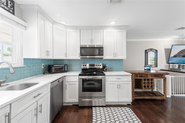 116 Westend Ave Unit 12, Freeport, NY 11520 - kitchen featuring appliances with stainless steel finishes, a sink, light countertops, dark wood-type flooring, and white cabinets