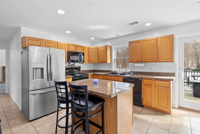 594 County Route 22, Middletown, NY 10940 - kitchen with black appliances, a sink, light tile patterned floors, a center island, and a breakfast bar area