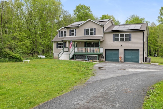 594 County Route 22, Middletown, NY 10940 - view of front of property featuring a porch, a front lawn, a garage, driveway, and roof mounted solar panels