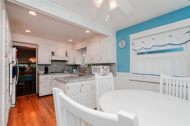 433 Arlene St, Staten Island, NY 10314 - kitchen with stainless steel gas stovetop, a wainscoted wall, light wood-type flooring, a ceiling fan, and white cabinets