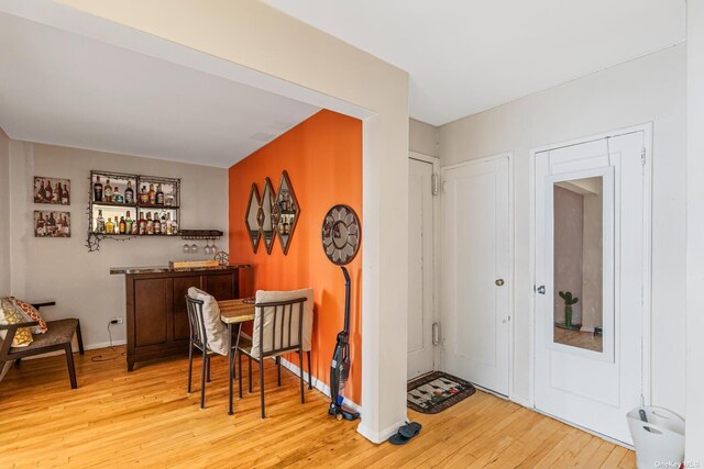 bar area featuring light wood-type flooring and baseboards