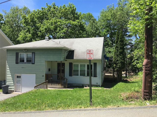 29 Nelshore Dr, Monticello, NY 12701 - view of front of house featuring a front lawn, an attached garage, and a shingled roof