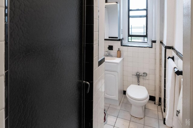 35-06 88th St Unit 5E, Jackson Heights, NY 11372 - bathroom featuring tile walls, tile patterned floors, toilet, vanity, and a shower stall