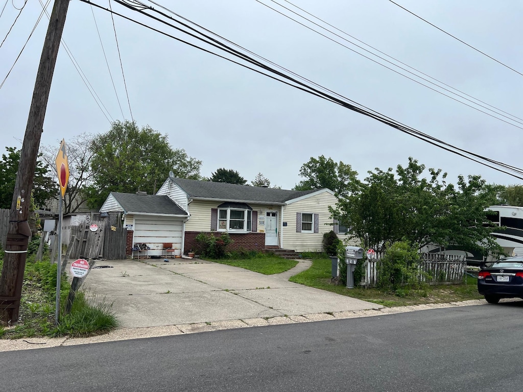 21 Pinetop Dr, Central Islip, NY 11722 - view of front of property with fence, brick siding, and concrete driveway