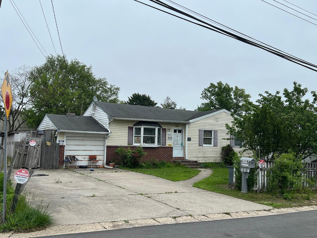 21 Pinetop Dr, Central Islip, NY 11722 - view of front facade with brick siding, a garage, driveway, and fence