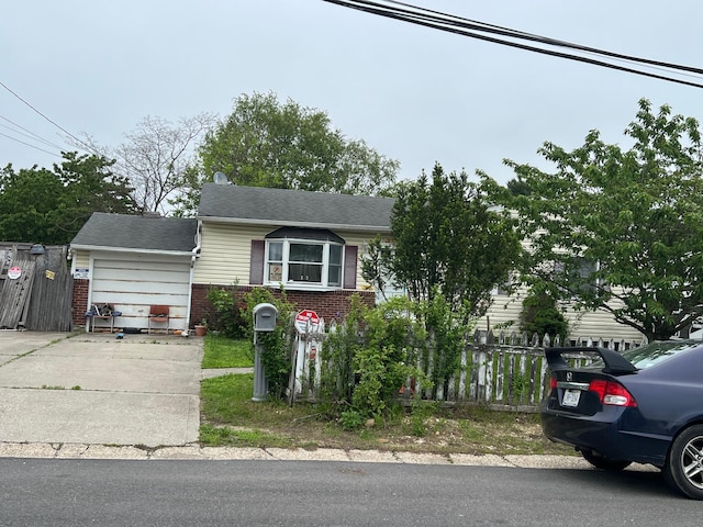21 Pinetop Dr, Central Islip, NY 11722 - view of front of home with brick siding, driveway, fence, and a garage