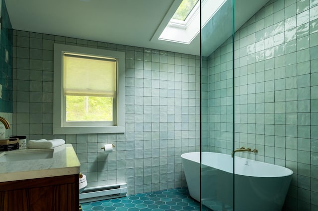35 Jilroy Ln, Spencertown, NY 12165 - full bath featuring tile walls, a baseboard heating unit, a soaking tub, a skylight, and vanity