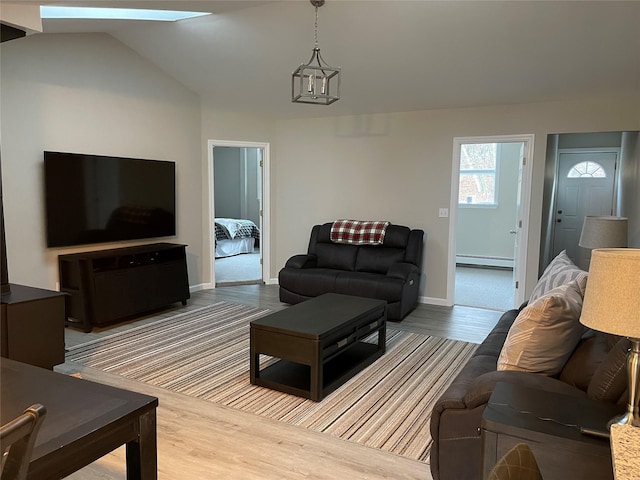 3412 Rte 52, Stormville, NY 12582 - living room featuring a baseboard radiator, wood finished floors, baseboards, and vaulted ceiling