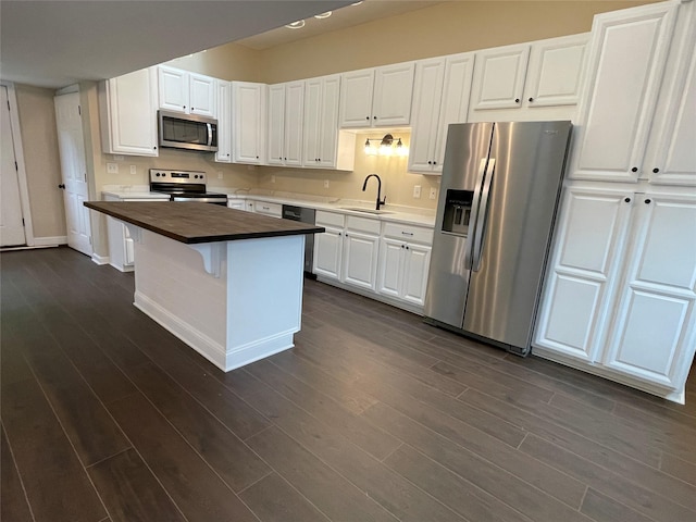 3412 Rte 52, Stormville, NY 12582 - kitchen featuring appliances with stainless steel finishes, wood counters, white cabinetry, dark wood-type flooring, and a kitchen island