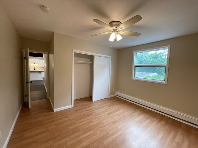 3412 Rte 52, Stormville, NY 12582 - unfurnished bedroom with baseboard heating, light wood-style floors, a closet, and baseboards