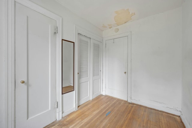 unfurnished bedroom featuring light wood-style floors and a closet