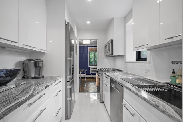 100 E Hartsdale Ave Unit Tfw, Hartsdale, NY 10530 - kitchen featuring appliances with stainless steel finishes, modern cabinets, white cabinets, light stone counters, and decorative backsplash