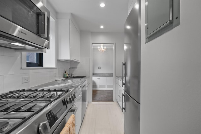 100 E Hartsdale Ave Unit Tfw, Hartsdale, NY 10530 - kitchen with appliances with stainless steel finishes, a sink, white cabinetry, recessed lighting, and light stone countertops
